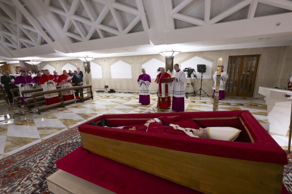 Pope Francis's body is laid out in state inside his private chapel at the Vatican, Monday, April 21, 2025. From left front row, Secretary of State Pietro Parolin, Dean Cardinal Giovanni Battista Re, unidentified person, Master of Ceremonies Archbishop Diego Giovanni Ravelli, Cardinal Camerlengo Kevin Joseph Farrell, and Master of Ceremonies Lubomir Welnitz. (Vatican Media via AP, HO)