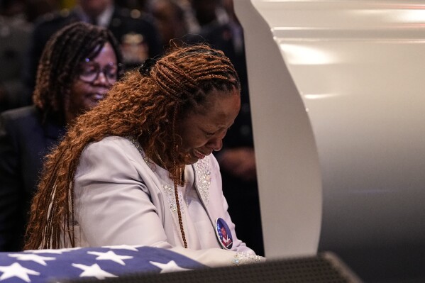 Chantemekki Fortson, left, the mother of slain airman Roger Fortson stands at his casket during his funeral at New Birth Missionary Baptist Church, Friday, May 17, 2024, near Atlanta. (AP Photo/Brynn Anderson)