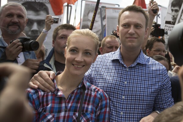 FILE - Russian opposition leader Alexei Navalny, right, and his wife, Yulia Navalnaya, left, attend an opposition rally outside the Kremlin in Moscow on June 12, 2013. Navalnaya used to largely avoid the cameras, staying in the background while her husband rose to become President Vladimir Putin's greatest challenger. Shortly after his death, that changed as she vowed to continue his work. (APPhoto/Alexander Zemlianichenko, File)