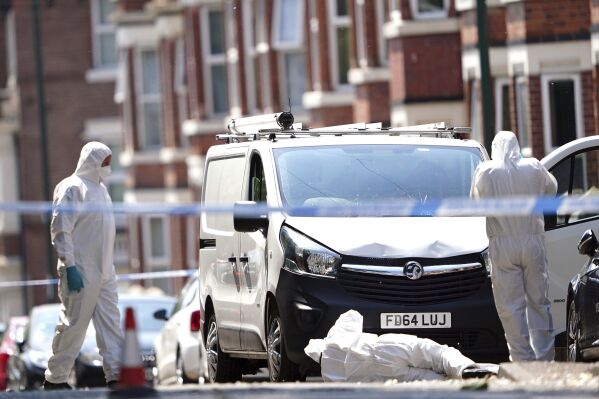 Police forensics officers search a white van on the corner of Maples Street and Bentinck Road in Nottingham, as three people have been found dead in the city in what police described as a "horrific and tragic incident". A 31-year-old man has been arrested on suspicion of murder after two people were found dead in the street in Ilkeston Road just after 4am on Tuesday. A third man was found dead in Magdala Road, Nottinghamshire Police said. Another three people are in hospital after someone tried to run them over in a van in Milton Street, in what police believe was a connected incident, Tuesday June 13, 2023. (Zac Goodwin/PA via AP)