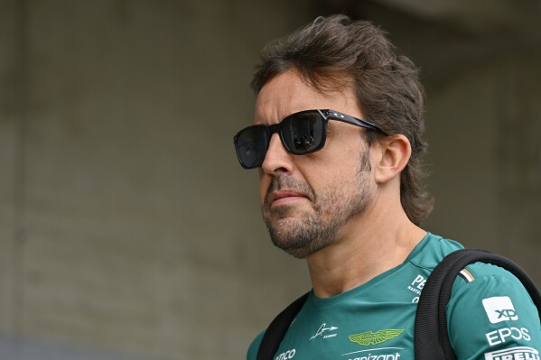 Spanish Formula One driver Fernando Alonso of Aston Martin arrives in the paddock ahead of the first practice session ahead of Sunday's Formula One Hungarian Grand Prix auto race, at the Hungaroring racetrack in Mogyorod, near Budapest, Hungary, Friday, July 21, 2023. (AP Photo/Denes Erdos)