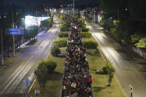 FILE - Migrants fill the top of a northbound freight train in Irapuato, Mexico, Sept. 23, 2023. Thousands of other migrants were stranded in other parts of the country after Mexico's biggest railroad said it halted 60 freight trains, citing so many migrants hitching rides that it became unsafe to move the trains. (AP Photo/Marco Ugarte, File)