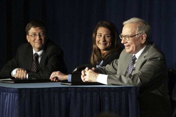 Bill Gates, left, Melinda Gates and Warren Buffett speak during a press conference, June 26, 2006 in New York. (AP Photo/Seth Wenig, File)