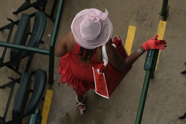 A race fan arrives at Churchill Downs before the 150th running of the Kentucky Derby horse race Saturday, May 4, 2024, in Louisville, Ky. (AP Photo/Charlie Riedel)
