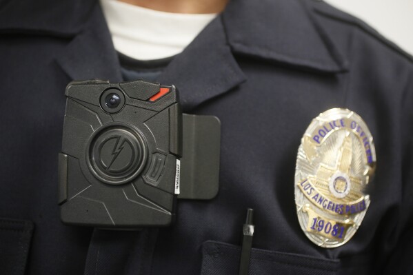 FILE - A Los Angeles Police officer wears an on-body cameras during a demonstration for media in Los Angeles, Jan. 15, 2014. An influential policing think tank is pushing law enforcement agencies to change how they handle body camera footage after police shootings, saying officers should not be able to review video before making their first statements to investigators. (AP Photo/Damian Dovarganes,File)