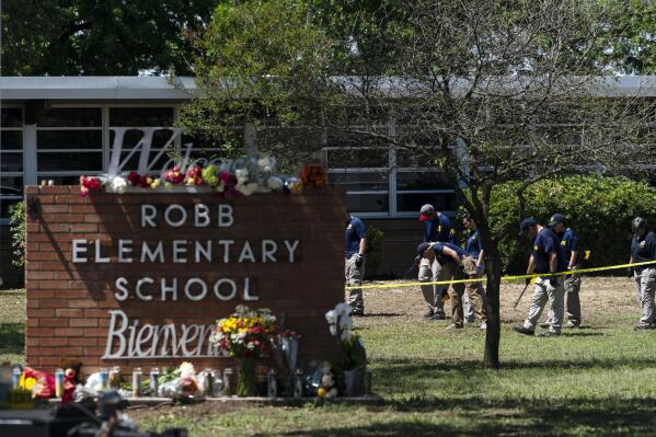 FILE - Investigators search for evidences outside Robb Elementary School in Uvalde, Texas, May 25, 2022, after an 18-year-old gunman killed 19 students and two teachers. Uvalde Consolidated Independent School District Police Chief Pete Arredondo, who served as on-site commander during the shooting, said that he's talking daily with investigators, contradicting claims from state law enforcement that he has stopped cooperating. (AP Photo/Jae C. Hong, File)