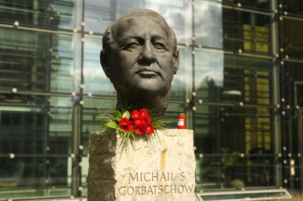 Flowers and a candle are placed at a bust of the former Soviet President Mikhail Gorbachev at the Axel Springer Publisher House in Berlin, Germany, Wednesday, Aug. 31, 2022. Russian news agencies are reporting that former Soviet President Mikhail Gorbachev has died at 91. The Tass, RIA Novosti and Interfax news agencies cited the Central Clinical Hospital. (AP Photo/Markus Schreiber)