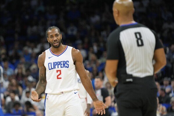 Los Angeles Clippers forward Kawhi Leonard (2) question a call by official Marc Davis (8) during the second half of an NBA basketball game against the Orlando Magic, Friday, March 29, 2024, in Orlando, Fla. (AP Photo/John Raoux)