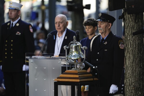 A a bell is rung at 9:03a.m. by a member of the FDNY during the 9/11 Memorial ceremony on the 23rd anniversary of the Sept. 11, 2001 terror attacks, Wednesday, Sept. 11, 2024, in New York. (AP Photo/Pamela Smith)