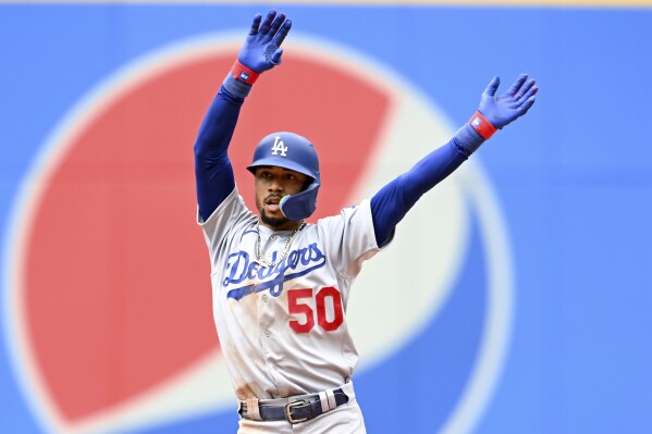 Los Angeles Dodgers' Mookie Betts celebrates hitting a two-run double during the eighth inning in the continuation of a suspended baseball game against the Cleveland Guardians, Thursday, Aug. 24, 2023, in Cleveland. The game was suspended the night before due to inclement weather. (AP Photo/Nick Cammett)