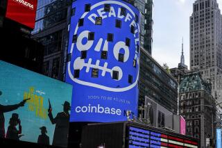 FILE - An advertisement for Coinbase, center, is displayed on NASDAQ billboard in Times Square, New York, Thursday, Nov. 4, 2021. Coinbase Global says, Tuesday, June 14, 2022,  it plans to cut about 1,100 jobs, or approximately 18% of its global workforce, as part of a restructuring in order to help manage its operating expenses in response to current market conditions. The company said in a regulatory filing that it expects to have about 5,000 total employees at the end of its current fiscal quarter on June 30.  (AP Photo/Seth Wenig, File)