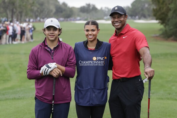 Charlie Woods, left, sister Sam, center and father Tiger, right stand together at 1st tee during the final round of the PNC Championship golf tournament Sunday, Dec. 17, 2023, in Orlando, Fla. (AP Photo/Kevin Kolczynski)