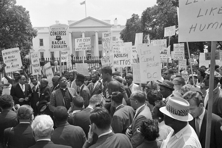 FILE - A group of demonstrators pause in front of the White House for a prayer, June 14, 1963. Leading the demonstrators is Bishop Smallwood Williams, slightly left of center, of Washington. They’re hallmarks of American history: protests, rallies, sit-ins, marches, disruptions. They date from the early days of what would become the United States to the sights and sounds currently echoing across the landscapes of the nation’s colleges and universities. (AP Photo/Henry Burroughs, File)