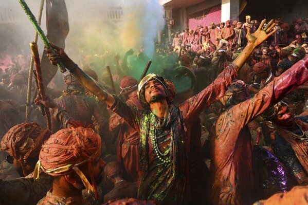 Residentes de Barsana y Nandgaon, cubiertos de polvo de colores, cantan y bailan mientras participan en el Lathmar Holi en el templo de Nandagram, en Nandgoan, a 115 kms (70 millas) al sur de Nueva Delhi, India, el 9 de marzo de 2025. (AP Foto)