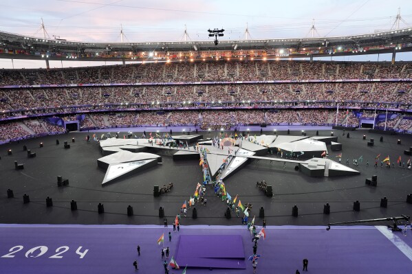 Flagbearers arrive on the pitch during the 2024 Summer Olympics closing ceremony at the Stade de France, Sunday, Aug. 11, 2024, in Saint-Denis, France. (AP Photo/David Goldman)