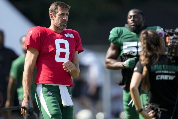 New York Jets quarterback Aaron Rodgers (8) warms up during a joint NFL football camp with the Carolina Panthers Wednesday, Aug. 9, 2023, in Spartanburg, S.C. (AP Photo/Mike Stewart)