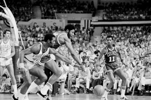 FILE - John Wetzel of the Phoenix Suns sidesteps Boston's Jo Jo White as White prepares a shot during the final game of the NBA playoffs in Phoenix, Ariz., June 6, 1976. The Celtics won the game and the championship 87-80 for their 13th title. (AP Photo/Jim Palmer, File)