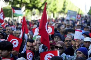People commemorate the 13th anniversary of the Tunisian uprising in Avenue Habib Bourguiba, Tunis, Jan. 14, 2024. (AP Photo/Hassene Dridi)