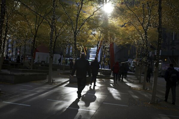FILE - In this Nov. 14, 2018, file photo people walk through lower Manhattan's Zuccotti Park at the start of a work day in New York.A new study finds that only 4% of retirees start claiming their Social Security benefits at the most financially optimal time. And current retirees collectively will lose $3.4 trillion in potential income to fund their retirement because they started drawing benefits at a less than ideal time. That’s roughly $111,000 per household, according to the research from United Income, an online investment management and financial planning firm. (AP Photo/Wong Maye-E, File)