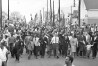 Dr. Martin Luther King, fourth from right, waves as marchers stream across the Alabama River on the first of a five day, 50 mile march to the state capitol at Montgomery, Ala., on March 21, 1965. (AP Photo)