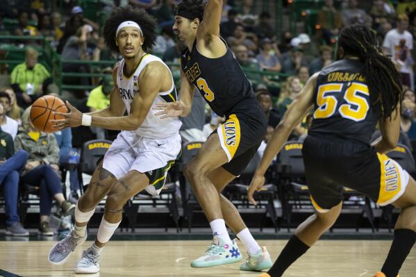 Baylor guard Kendall Brown (2) drives past Arkansas-Pine Bluff forward Trey Sampson (23) while looking for an open teammate in the first half of an NCAA college basketball game in Waco, Texas, Saturday, Dec. 4, 2021. (AP Photo/Emil Lippe)