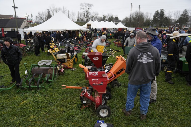 Young people walk amongst buggies that will be auctioned off during the 56th annual mud sale to benefit the local fire department in Gordonville, Pa., Saturday, March 9, 2024. (AP Photo/Matt Rourke)