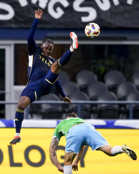 Vancouver Whitecaps defender Javain Brown, top, collides with Seattle Sounders midfielder Albert Rusnák while going up for the ball during the first half of an MLS soccer match Saturday, May 18, 2024, in Seattle. (AP Photo/Lindsey Wasson)