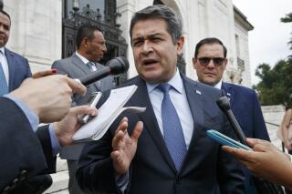 FILE - Honduran President Juan Orlando Hernandez answers questions from the Associated Press, Tuesday, Aug. 13, 2019, as he leaves a meeting at the Organization of American States, in Washington. The U.S. government is formally requesting on Monday, Feb. 14, 2022, the arrest and extradition of ex-president Hernandez. (AP Photo/Jacquelyn Martin,File)