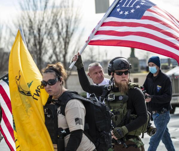 FILE - Chester Doles, rear center, leader of American Patriots USA, is surrounded by supporters as he makes his way to a 'Stop the Steal' rally outside of the Georgia State Capitol building, Wednesday, Jan. 6, 2021, in Atlanta. During the tumultuous period immediately following the November 2020 presidential election, election workers across the country faced harassment and threats. Since then, legislators in a small but growing number of states have proposed measures to help protect those workers by creating or boosting penalties for such threats or assaults. (Alyssa Pointer/Atlanta Journal-Constitution via AP, File)