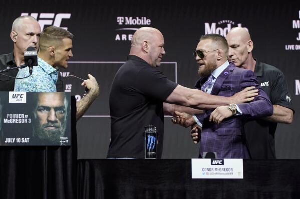 Dana White, center, UFC President, holds Conor McGregor away from Dustin Poirier during a news conference for a UFC 264 mixed martial arts bout Thursday, July 8, 2021, in Las Vegas. (AP Photo/John Locher)