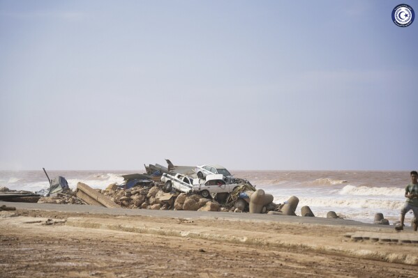 In this photo provided by the Libyan government, cars sit piled on the sea bank in Derna, Libya, on Monday, Sept. 11, 2023, after being carried by floodwaters. Mediterranean storm Daniel caused devastating floods in Libya that broke dams and swept away entire neighborhoods and wrecked homes in multiple coastal towns in the east of the North African nation. As many as 2,000 people were feared dead one of the country's leaders said. (Libyan government via AP)