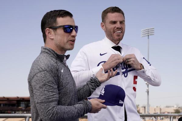 Los Angeles Dodgers president of baseball operations Andrew Friedman, left, announces the arrival of free agent Freddie Freeman during a news conference at spring training baseball, Friday, March 18, 2022, in Glendale, Ariz. (AP Photo/Charlie Riedel)