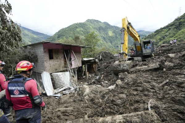A tractor removes the debris caused by a landslide in El Placer, Ecuador, Monday, June 17, 2024. (AP Photo/Dolores Ochoa)