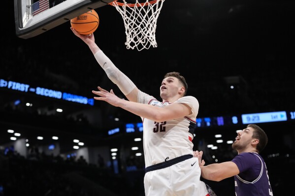 UConn center Donovan Clingan (32) goes to the basket against Northwestern forward Blake Preston during the first half of a second-round college basketball game in the NCAA Tournament, Sunday, March 24, 2024, in New York. (AP Photo/Mary Altaffer)