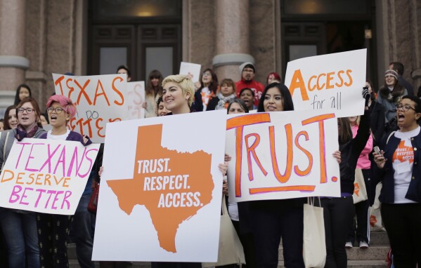 FILE - In this Feb. 26, 2015 file photo, college students and abortion rights activists hold signs during a rally on the steps of the Texas Capitol, in Austin, Texas. The Biden administration cannot use a 1986 emergency care law to require hospitals in Texas hospitals to provide abortions for women whose lives are at risk due to pregnancy, a federal appeals court ruled Tuesday, Jan. 2, 2024. It's one of numerous cases involving abortion restrictions that are playing out in state and federal courts after the U.S. Supreme Court ended abortion rights in 2022. (AP Photo/Eric Gay, File)