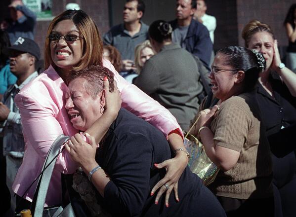 Two women hold each other as they watch the World Trade Center burn in New York Tuesday, Sept. 11, 2001. (AP Photo/Ernesto Mora)