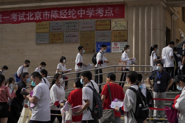 Estudiantes se forman para entrar a una escuela en el primer día de los exámenes de ingreso a la educación superior de China, conocido como el goakao, en Beijing, el martes 7 de junio de 2022. (AP Foto/Andy Wong, Archivo )