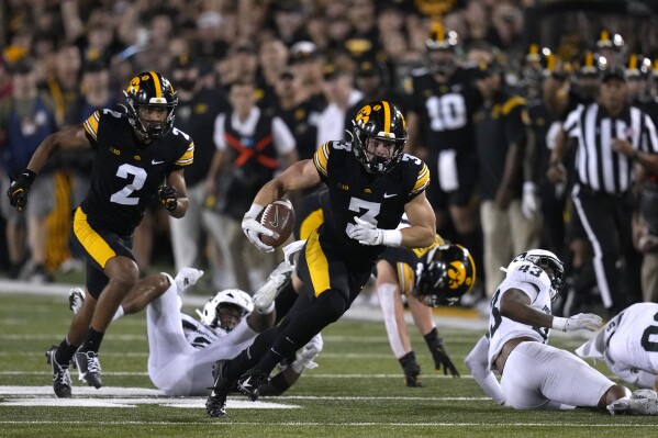 Iowa defensive back Cooper DeJean (3) returns a punt 70-yards for a touchdown during the second half of an NCAA college football game against Michigan State, Saturday, Sept. 30, 2023, in Iowa City, Iowa. Iowa won 26-16. (AP Photo/Charlie Neibergall)