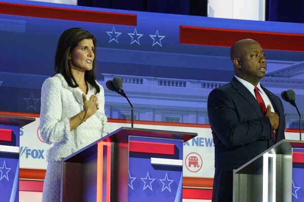 Republican presidential candidates former U.N. Ambassador Nikki Haley, and Sen. Tim Scott, R-S.C., stand on stage before a Republican presidential primary debate hosted by FOX News Channel Wednesday, Aug. 23, 2023, in Milwaukee. (AP Photo/Morry Gash)