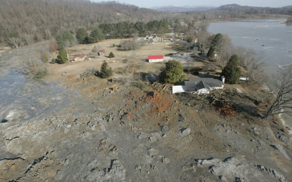 FILE - In this Dec. 22, 2008 file photo, an aerial view shows homes that were destroyed when a retention pond wall collapsed at the Tennessee Valley Authorities Kingston Fossil Plant in Harriman, Tenn. A backlash is growing from the Tennessee Valley Authority’s handling of the nation’s largest coal ash spill a decade ago. Workers said they were prohibited from wearing dust masks while cleaning up the ash and now suffer from cancers and lung diseases. The TVA contractor Jacobs Engineering denied their claims, saying the cleanup posed no health hazard.  (AP Photo/Wade Payne, File)