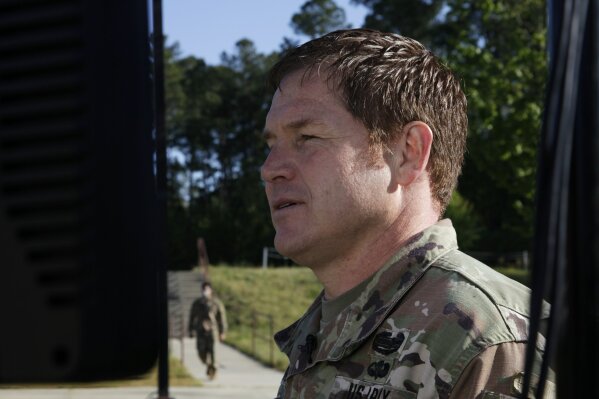 In this Thursday, April 16, 2020 photo, for his third Facebook sermon, U.S. Army Major Brian Minietta zeroes in on the topic of patience for the Green Berets of the 3rd Special Forces Group at Fort Bragg, N.C. While some training and deployments continue during the coronavirus pandemic, others have been put on hold. As soldiers spend more time than usual at home, Chaplain Minietta uses his messages to address possible family stressors soldiers might be facing. (AP Photo/Sarah Blake Morgan)