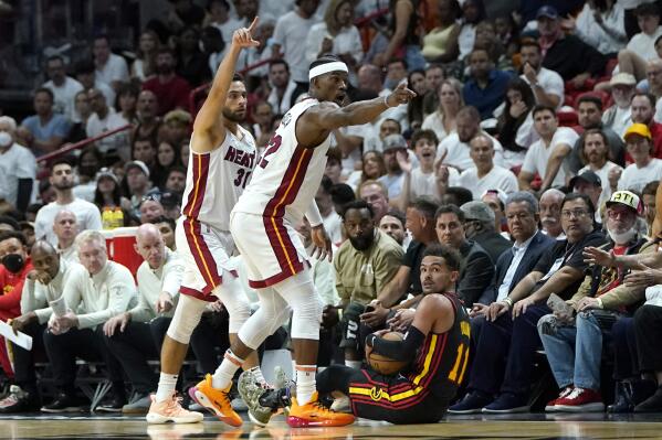 Miami Heat guard Max Strus, left, and forward Jimmy Butler (22) motion down the court for a Heat possession and Atlanta Hawks guard Trae Young loses control of the ball during the first half of Game 2 of an NBA basketball first-round playoff series, Tuesday, April 19, 2022, in Miami. (AP Photo/Lynne Sladky)