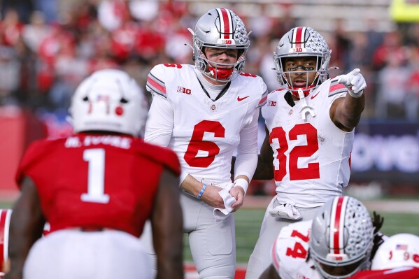Ohio State quarterback Kyle McCord (6) talks to running back TreVeyon Henderson (32) before a play against Rutgers during the second half of a NCAA college football game, Saturday, Nov. 4, 2023, in Piscataway, N.J. Ohio State won 35-16. (AP Photo/Noah K. Murray)