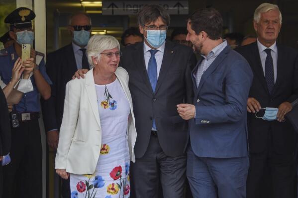 Catalan leader Carles Puigdemont, center, is flanked by European Parliament members Antoni Comin, right, and Clara Ponsati, left, as he leaves the Sassari law court, Italy, Monday, Oct. 4, 2021. Catalonia's former separatist leader Carles Puigdemont walked out of a Sardinian courthouse Monday after a judge delayed a decision on Spain's extradition request and said he was free to travel. First from right is Puigdemont's lawyer in Italy Agostinangelo Marras. (AP Photo/Gloria Calvi)