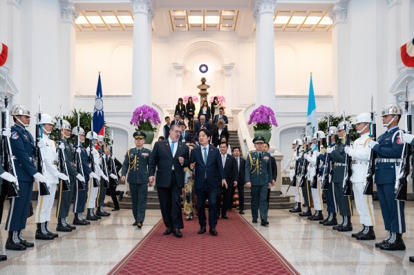 In this photo released by the Taiwan Presidential Office, Taiwan's President Lai Ching-te, center right, walks with Guatemalan President Bernardo Arévalo during a welcome ceremony in Taipei, Taiwan Thursday, June 5, 2025. (Taiwan Presidential Office via AP)