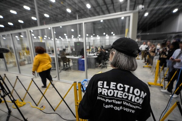 A non-partisan election volunteer observes as memory cards are uploaded from early voting at the Fulton County Election Hub and Operation Center, Nov. 5, 2024, in Atlanta, Mo. (AP Photo/John Bazemore, File)