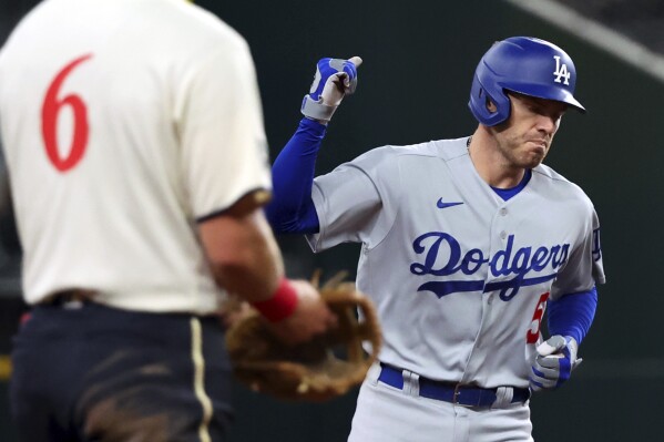 Los Angeles Dodgers' Freddie Freeman (5) pumps his fist as he runs the bases after a home run in the fifth inning against the Texas Rangers during a baseball game Friday, July 21, 2023, in Arlington, Texas. (AP Photo/Richard W. Rodriguez)