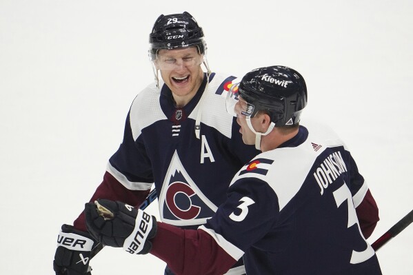Colorado Avalanche center Nathan MacKinnon (29) laughs with defenseman Jack Johnson (3) after an NHL hockey game against the Minnesota Wild Tuesday, April 9, 2024, in Denver. (AP Photo/Bart Young)