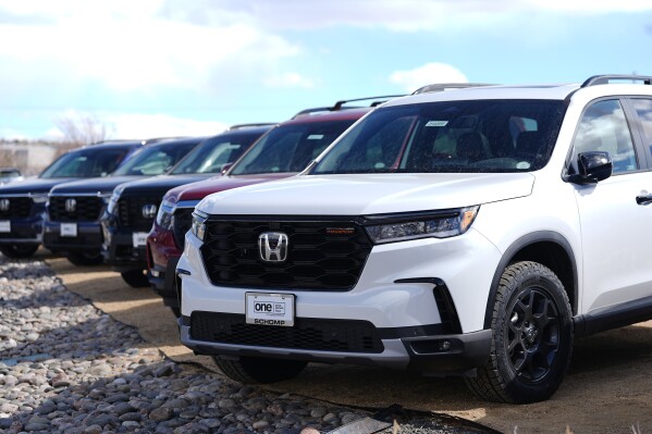 An unsold 2024 Honda Pilot and Passport SUVs sits at a dealership on March 3, 2024 in Highlands Ranch, Colo. Car shoppers who put off buying a new vehicle the past few years should be happy to see the return of promoted sales and discounts this summer.(AP Photo/David Zalubowski)