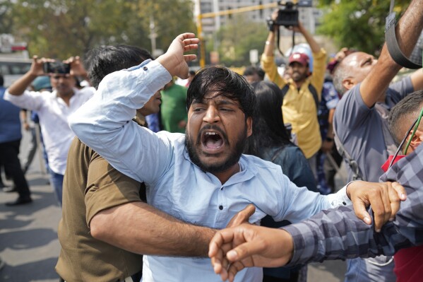 A supporter of Aam Admi Party, or Common Man's Party, shouts slogans as he is detained by a police official during a protest against the arrest of their party leader Arvind Kejriwal, in New Delhi, India, Friday, March 22, 2024. Supporters of an anti-corruption crusader and one of India's most consequential politicians of the last decade in India held protests Friday against his arrest, which opposition parties say is part of a crackdown by Prime Minister Narendra Modi's government before national elections. (AP Photo/Manish Swarup)